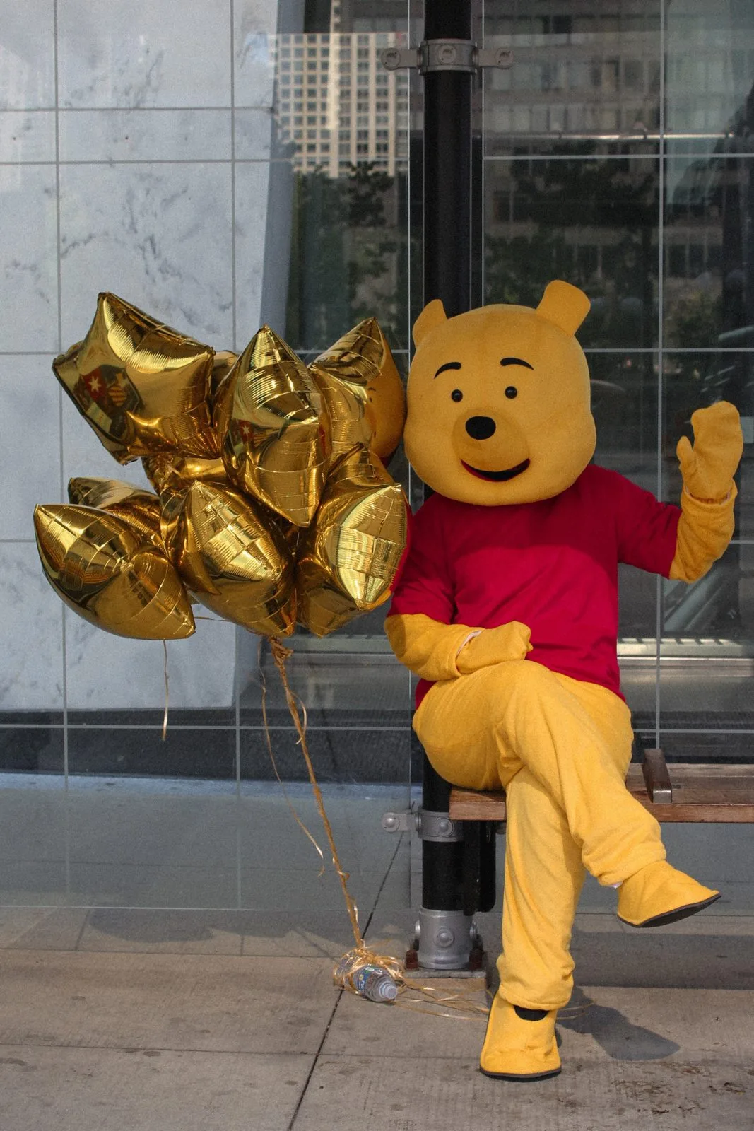 Winnie the Pooh mascot with golden star balloons