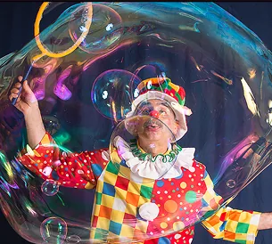 Bubble show clown surrounded by giant bubbles