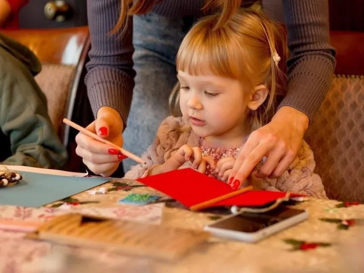 Holiday celebration with girl drawing greeting card