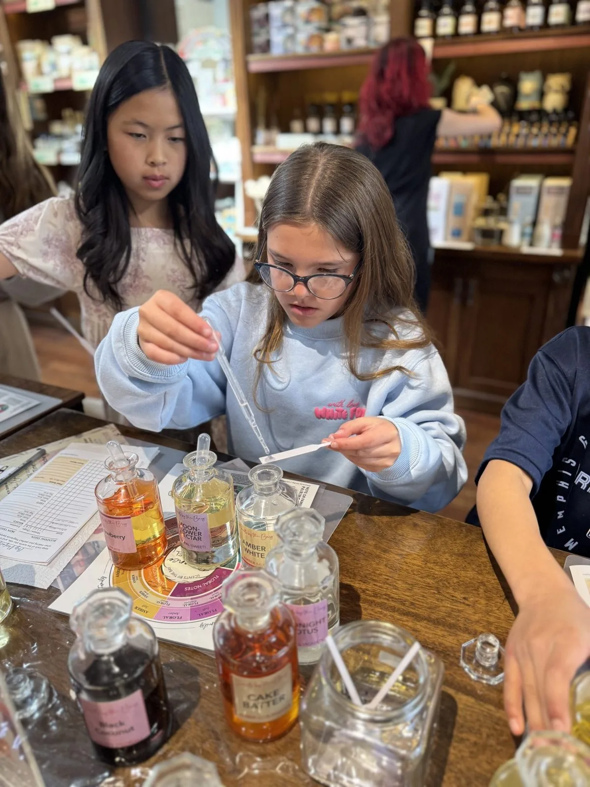 Girl carefully blending perfume scents with a dropper