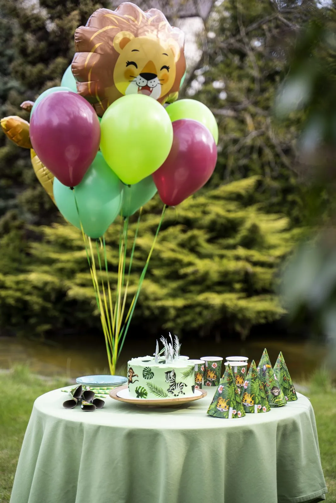 Jungle-themed birthday party with balloons and decorated cake