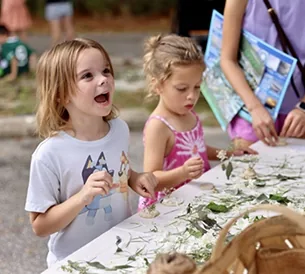 Kids arranging flowers and leaves at a craft table