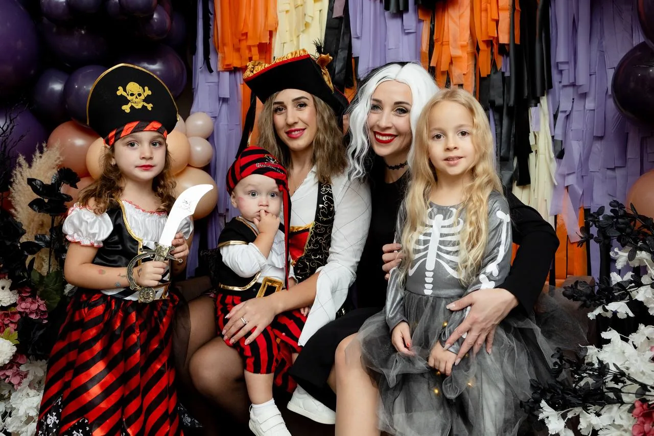 Kids and parents in Halloween costumes at a spooky-themed party
