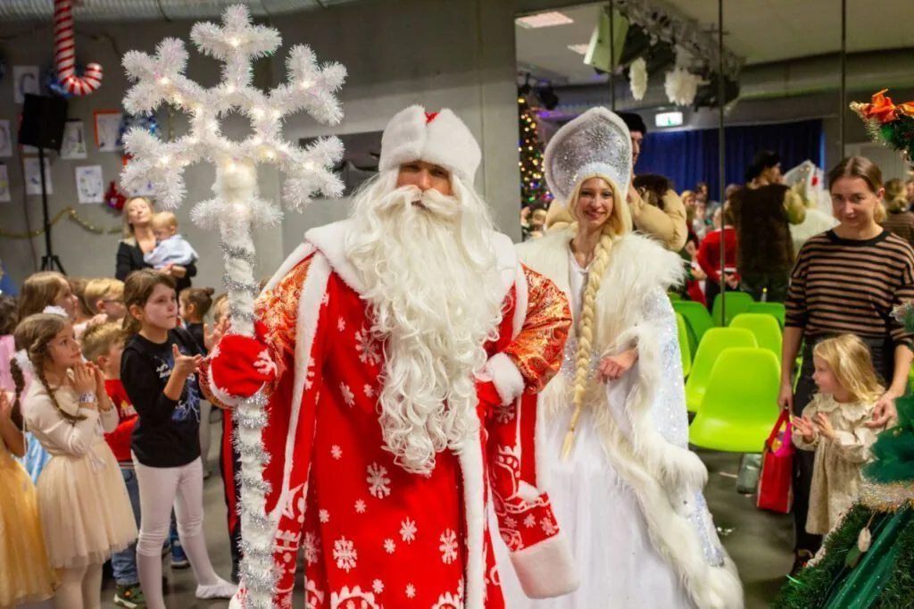 Santa and Snow Maiden greeting kids at a winter party